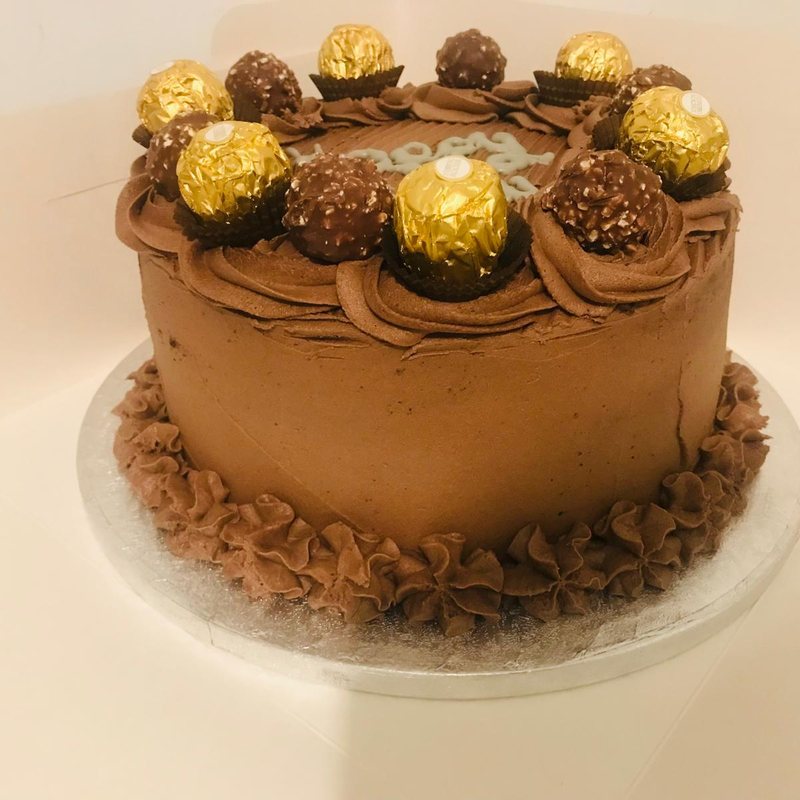 A chocolate celebration cake topped with Ferrero Rocher chocolates and finished with a piped chocolate border