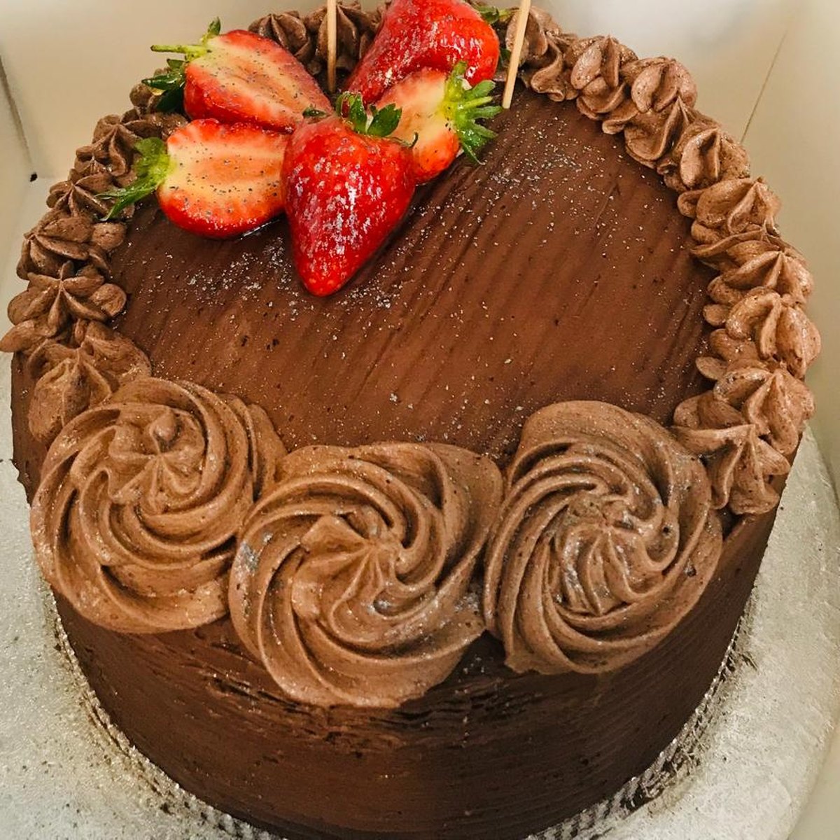 A chocolate fudge cake covered in piped chocolate buttercream and topped with fresh strawberries, baked in Medway, Kent
