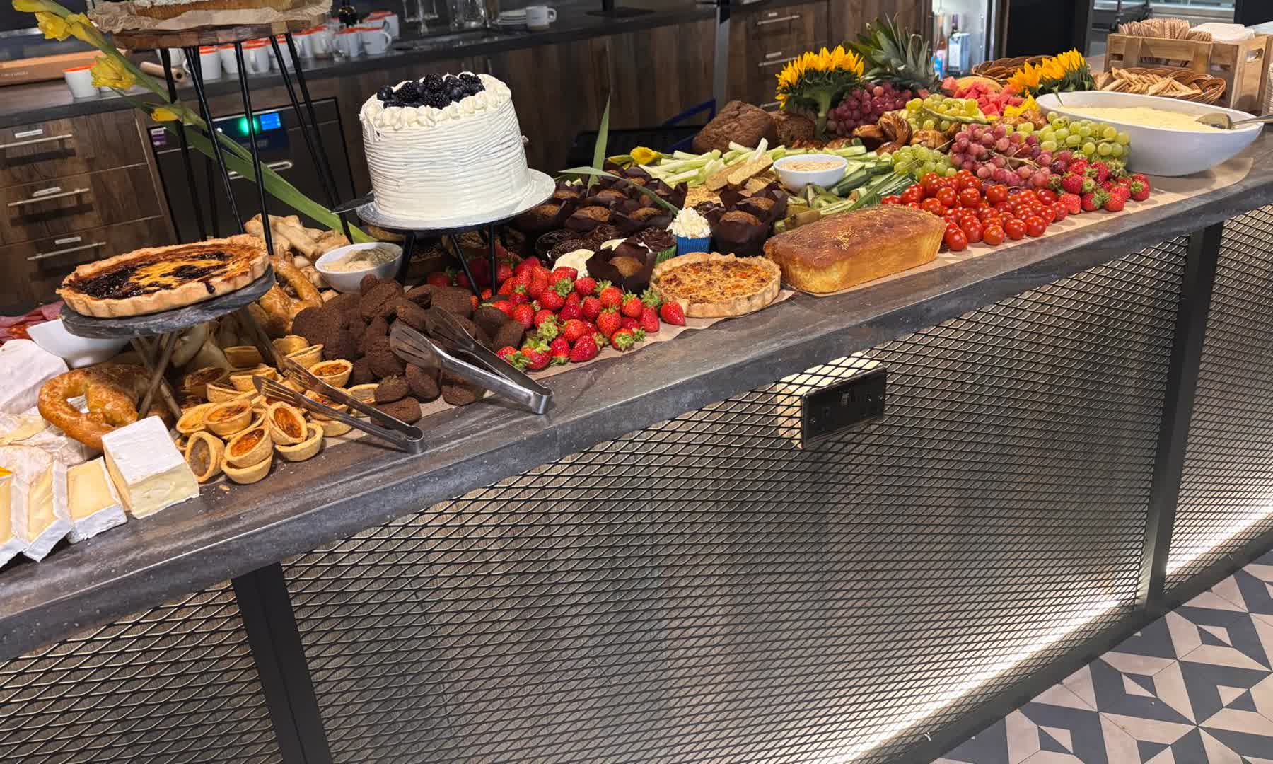 A full corporate grazing table catered by Kongwa Bakes, breads, cheeses and pastries laid out for a workplace event